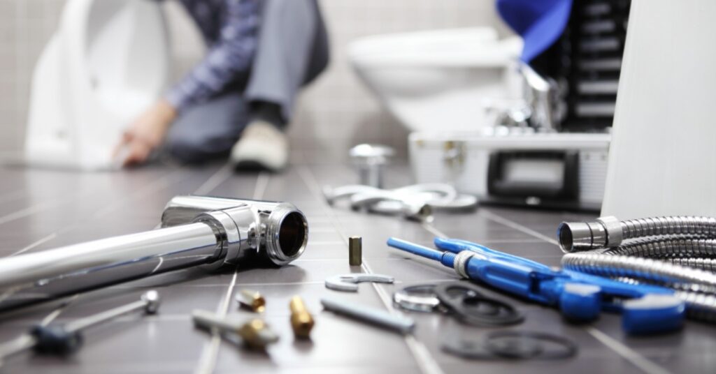 a plumber is working on a toilet in a bathroom
