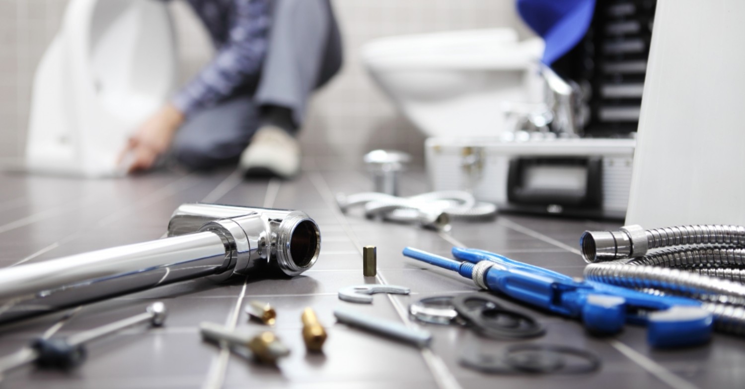 a plumber is working on a toilet in a bathroom