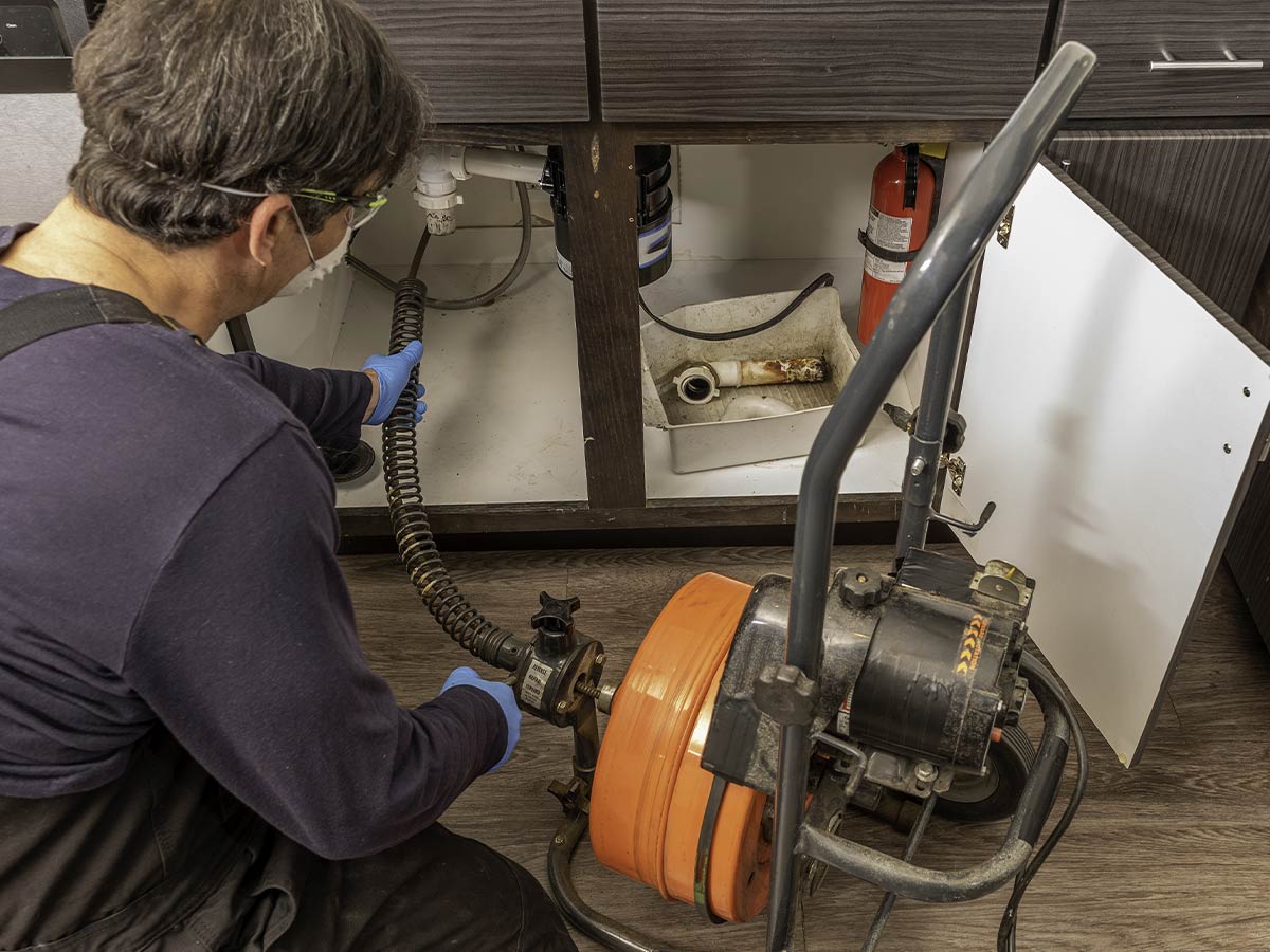 someone snaking a drain