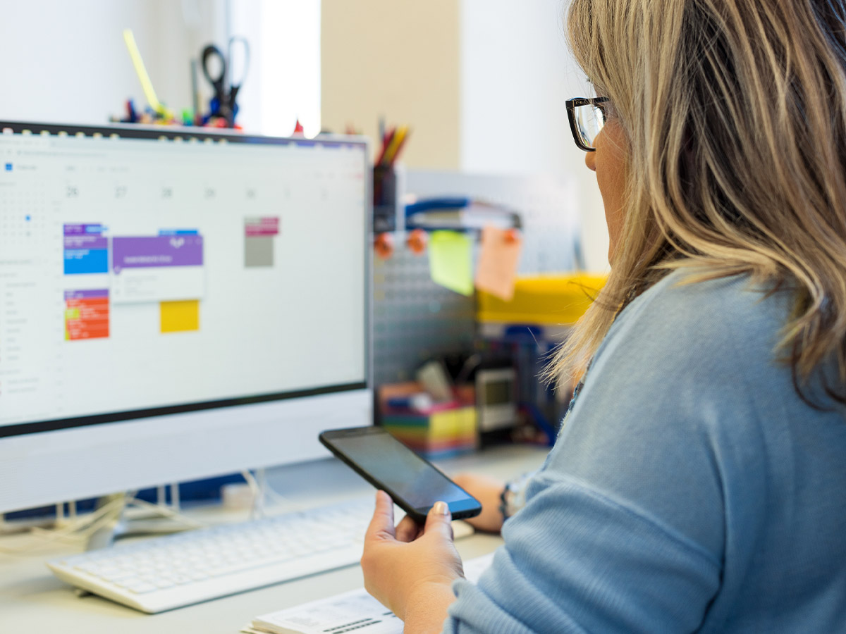a woman looking at her calendar with her phone in hand