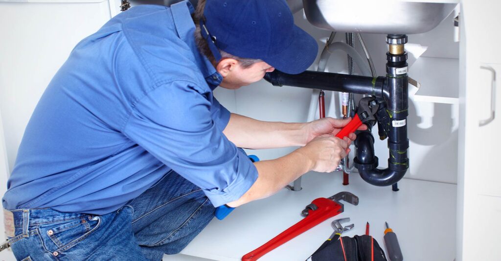 a plumber working under a sink