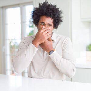 a person holding their nose in disgust