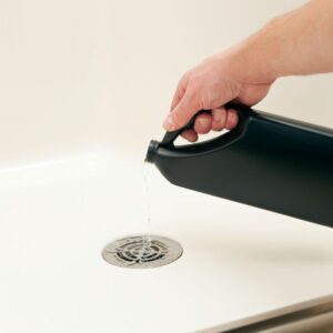 a person pouring chemicals down a drain