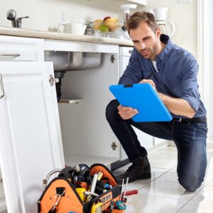 a plumber with a clipboard and tools