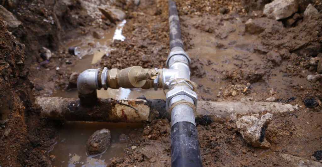 a metal pipe is connected to a metal pipe in the dirt
