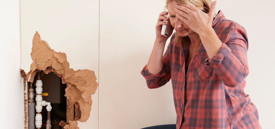 a woman is kneeling down next to a red bucket and talking on a cell phone
