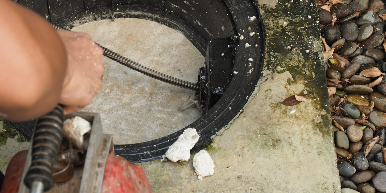 a person is using a machine to clean a drain