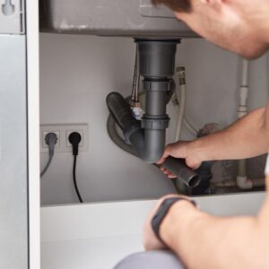 plumber looking at pipes