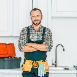 Professional plumber standing with his arms crossed, smiling. 
