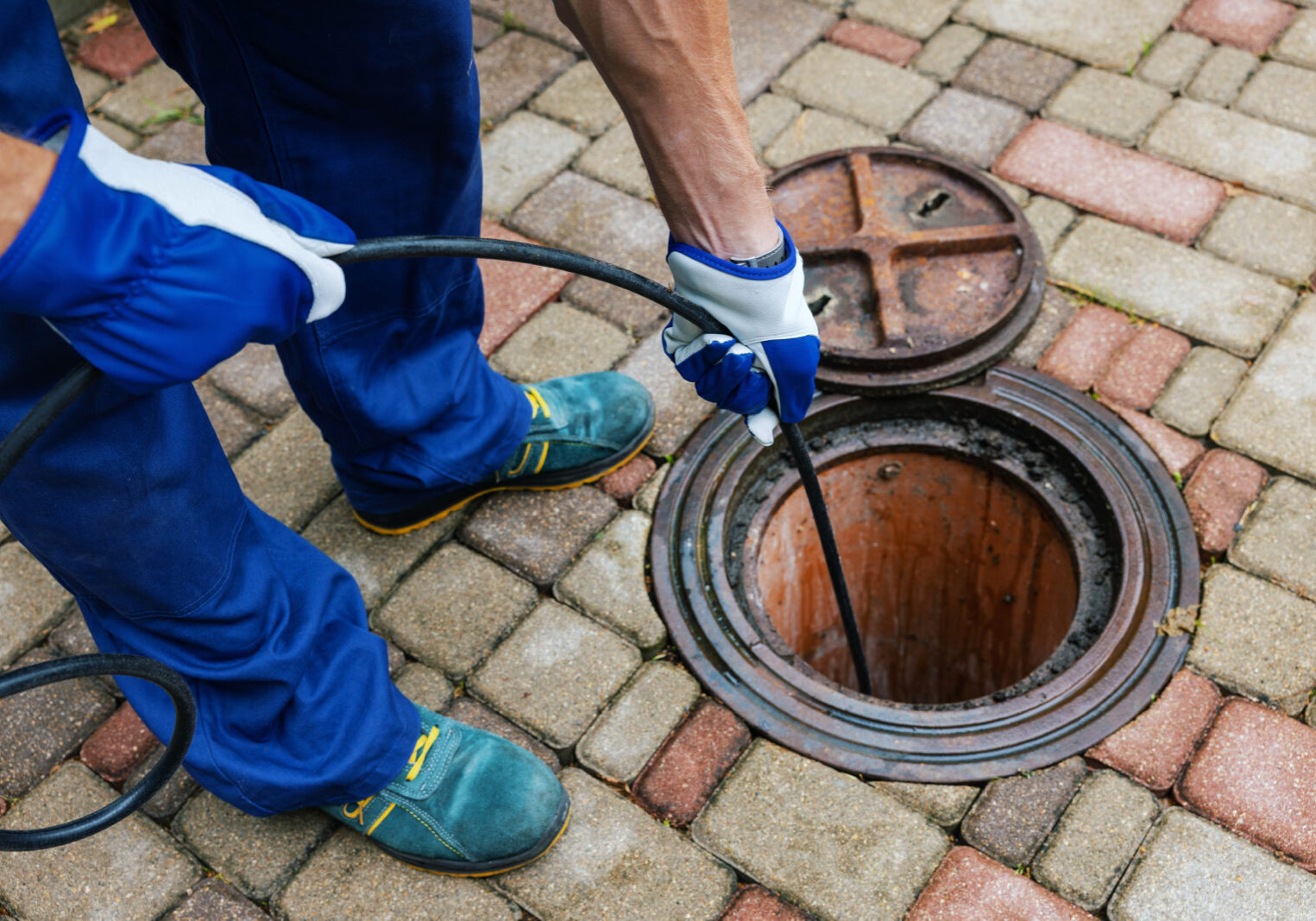 sewer cleaning service - worker clean a clogged drainage with hydro jetting
